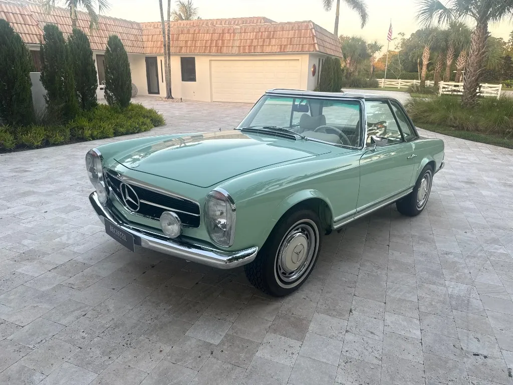 Classic mint green Mercedes SL Pagoda parked outside